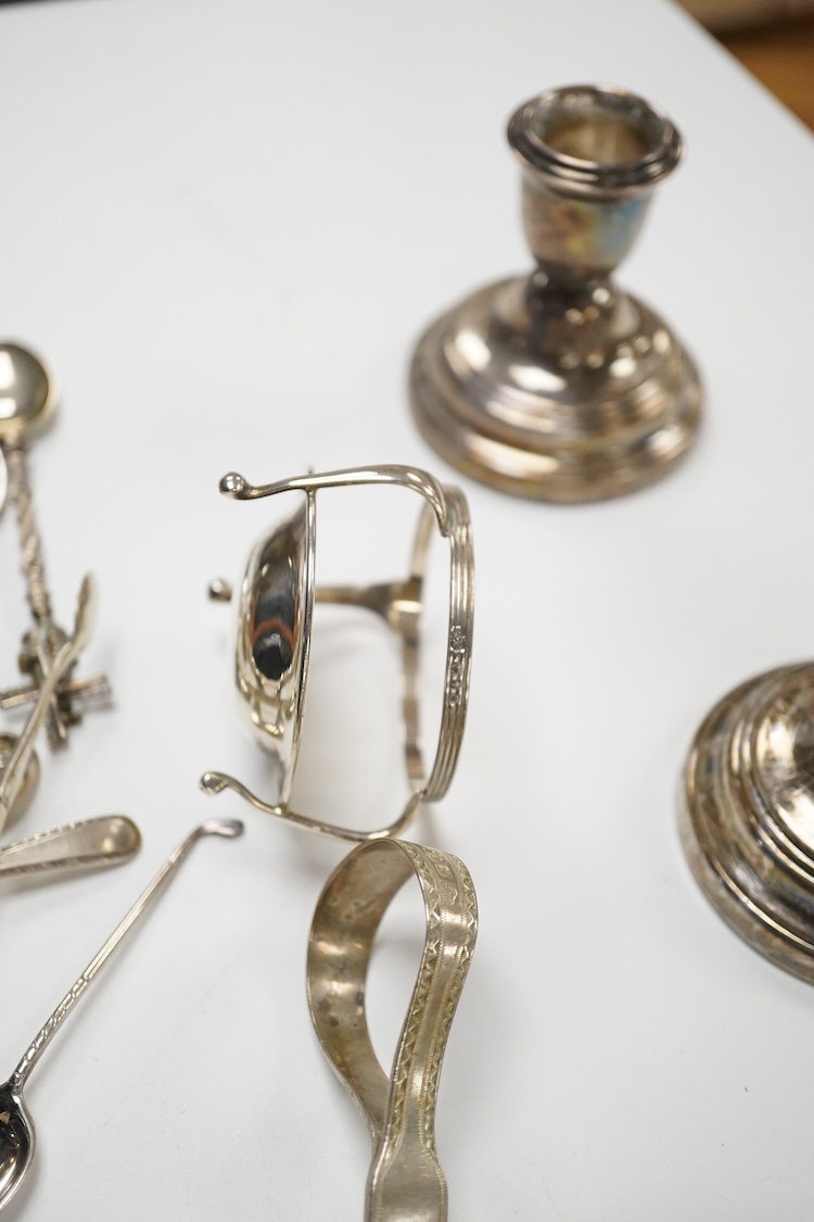 A small quantity of assorted small silver and plated flatware, a small silver stand, a silver napkin ring and a pair of modern silver mounted dwarf candlesticks.